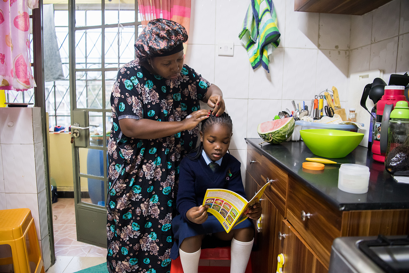 ©Gates Archive/Alissa Everett / Caption: Janet Memo helps her two children get ready for school while she cooks breakfast in her small apartment in Nairobi, Kenya on February 22, 2021. The COVID-19 pandemic has challenged many women to balance working from home and caring for their children. 