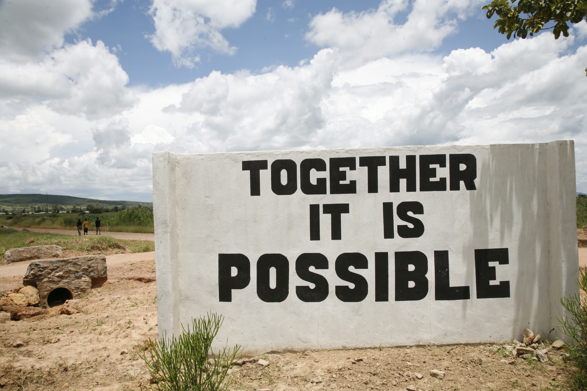 A sign that reads "Together It Is Possible" in large letters