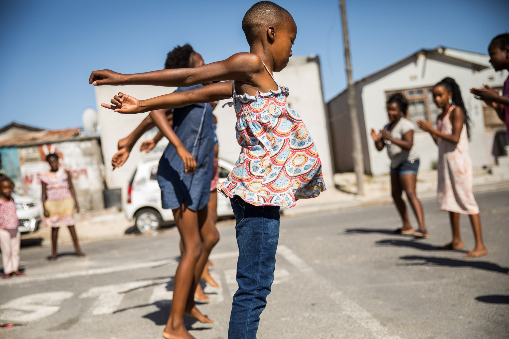 Children from neighboring streets converge to dance and play outside in Cape Town, South Africa