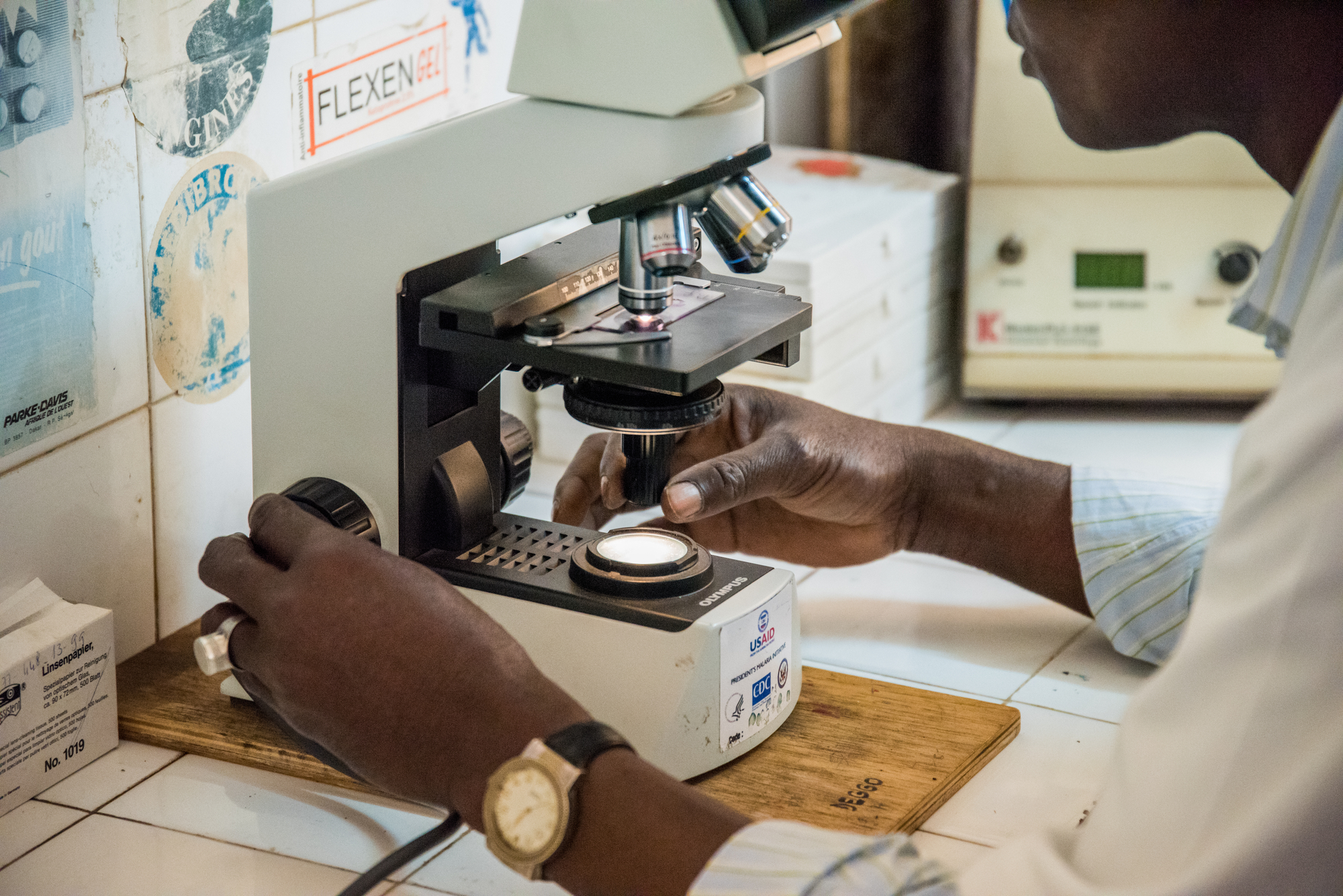 A medical staff member looks through a microscope to detect a blood sample if positive for malaria at the Deggo Health Centre in Pekine, Dakar, Senegal on March 13, 2017. The impact committee of the Lives and Livelihoods Fund (LLF) visited the center to learn more about the fight against malaria. 