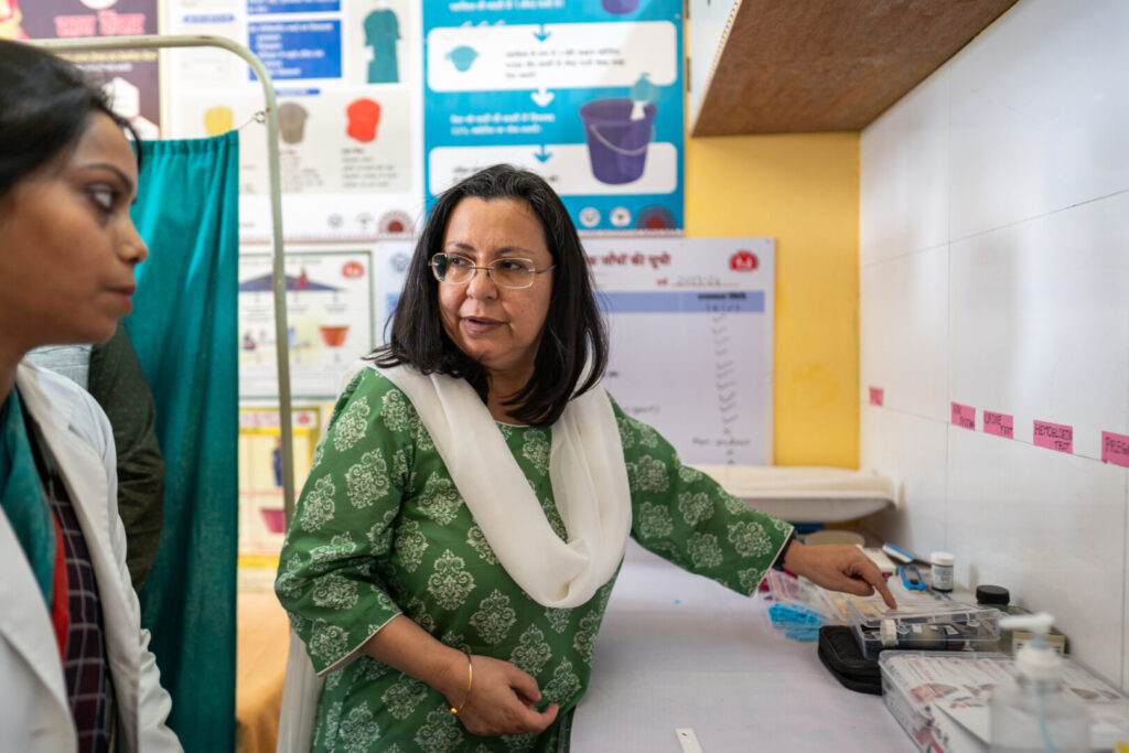 Anita Zaidi talks with Community Health Officer (CHO) Mithilesh about the services, screenings, and treatments available to patients at the Anaura Kala Health and Wellness Center in Lucknow, Uttar Pradesh, India on November 7, 2023.
