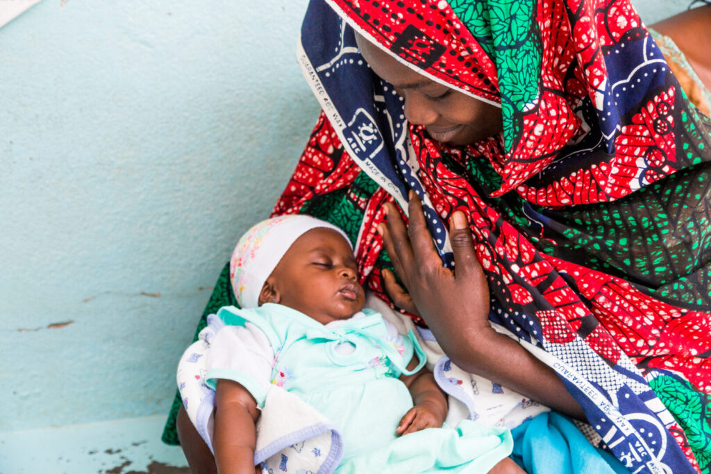 A mom waits with her child during a vaccination day at Palar's Health Center in Maroua, Cameroon on March 2, 2018.